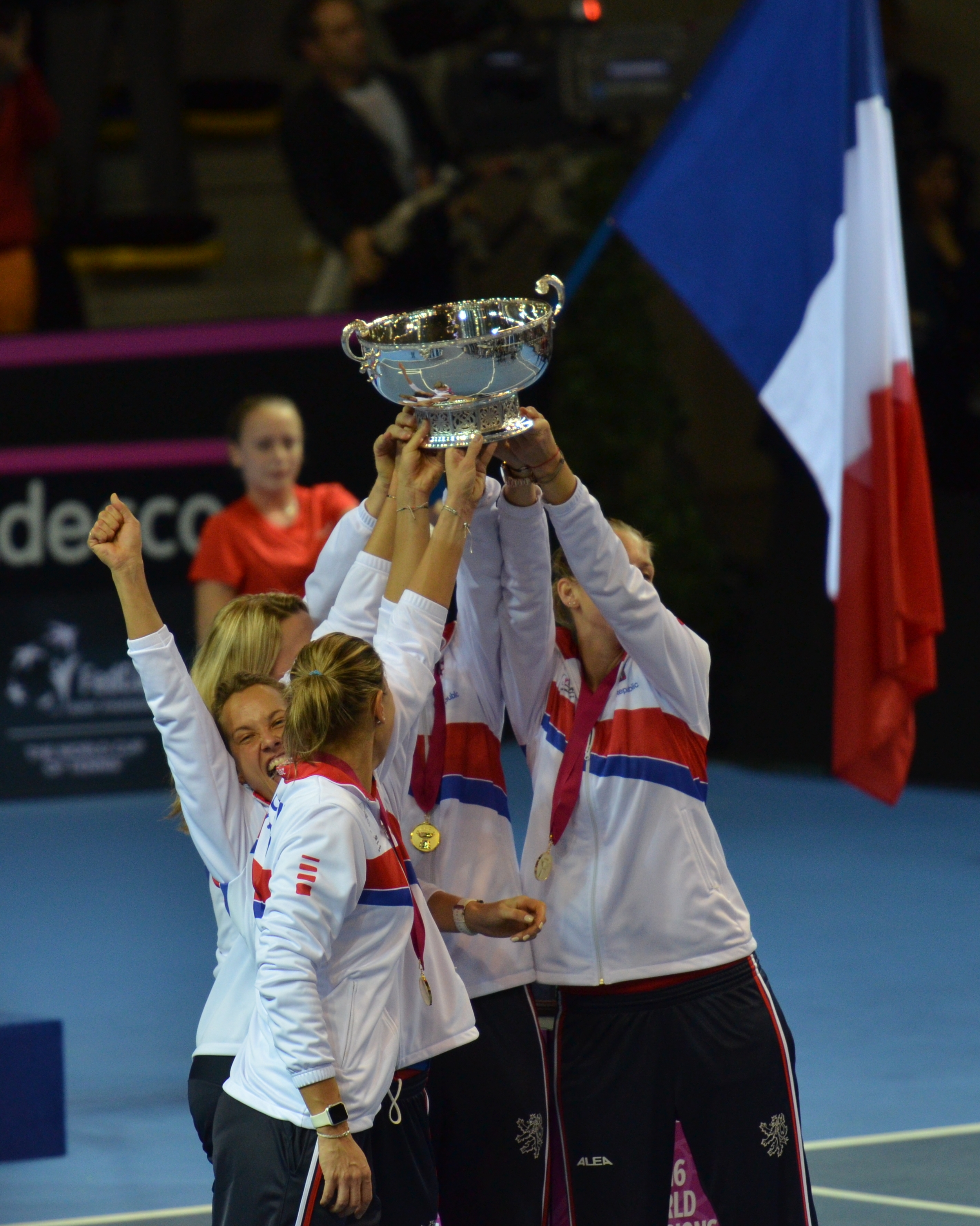 Tenistas da República Tcheca erguem o troféu prateado da Fed Cup durante a comemoração do título.