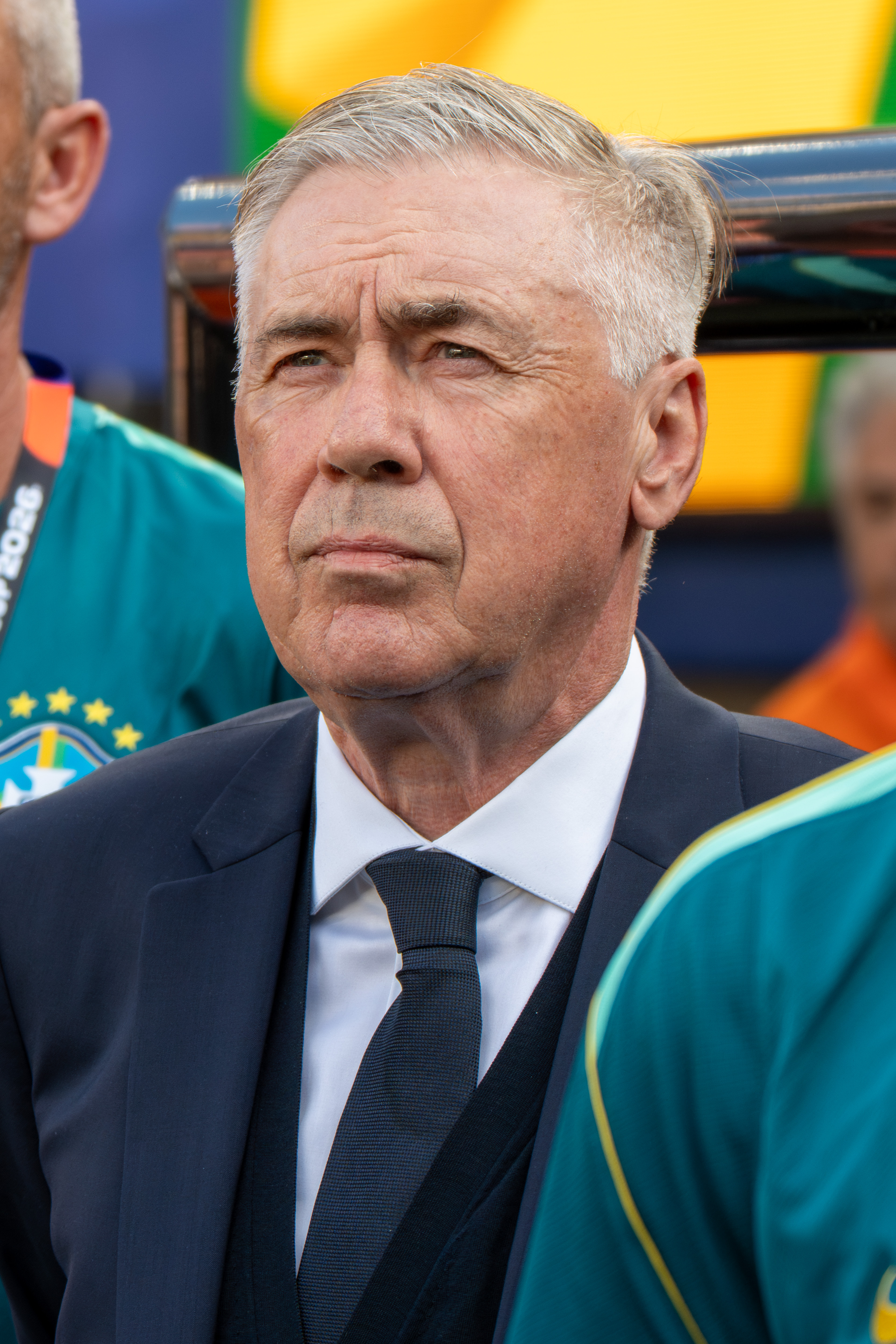 Carlo Ancelotti de terno e gravata junto à delegação brasileira durante a partida.