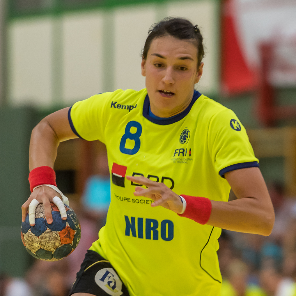 Cristina Neagu com a bola, vestindo a camisa 8 da seleção da Romênia.