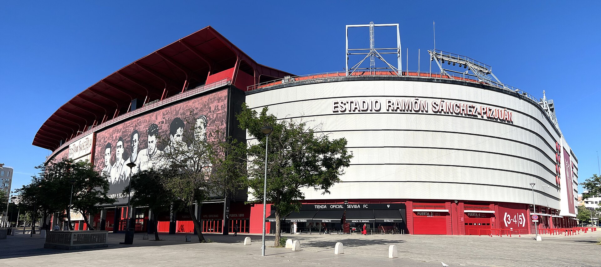 Fachada externa do Estádio Ramón Sánchez-Pizjuán, com árvores e área urbana ao redor.