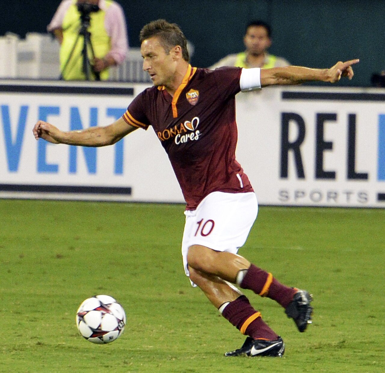 Francesco Totti conduz a bola em campo vestindo o uniforme da Roma.