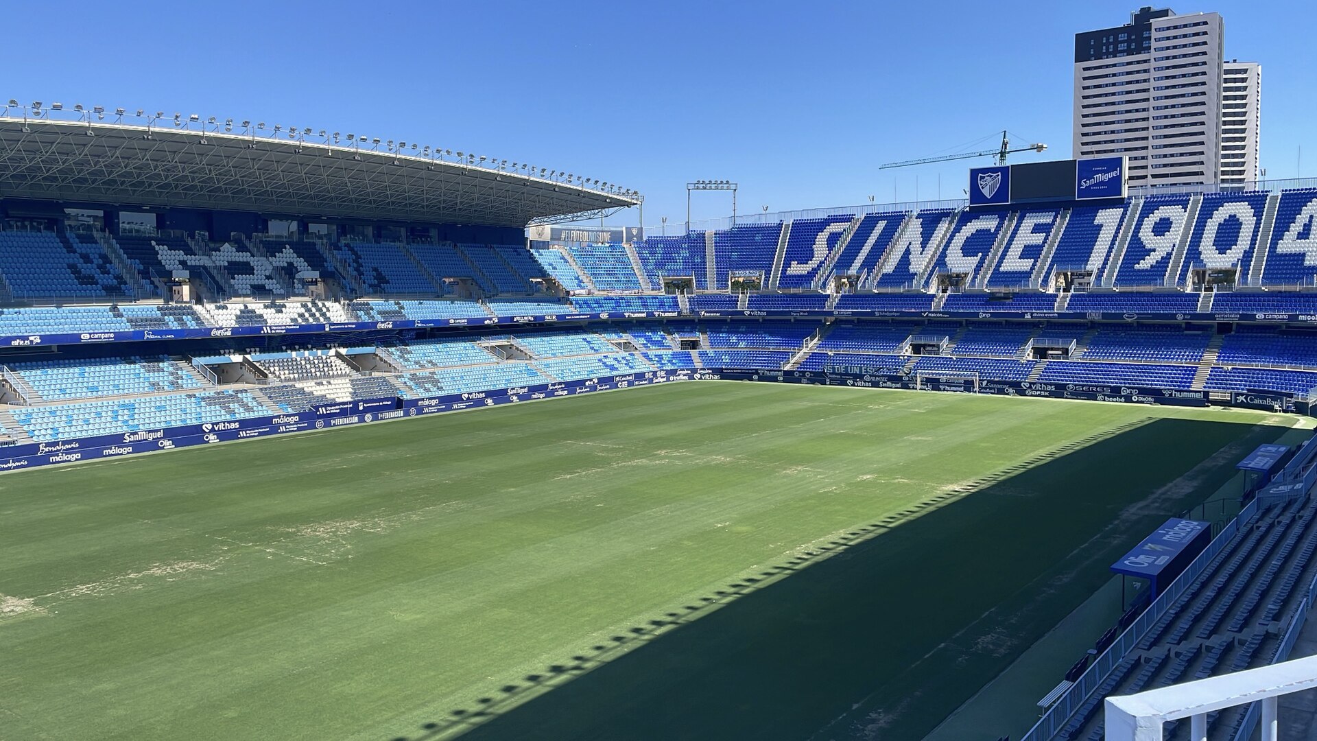 Gramado e arquibancadas azuis e brancas do Estádio La Rosaleda.