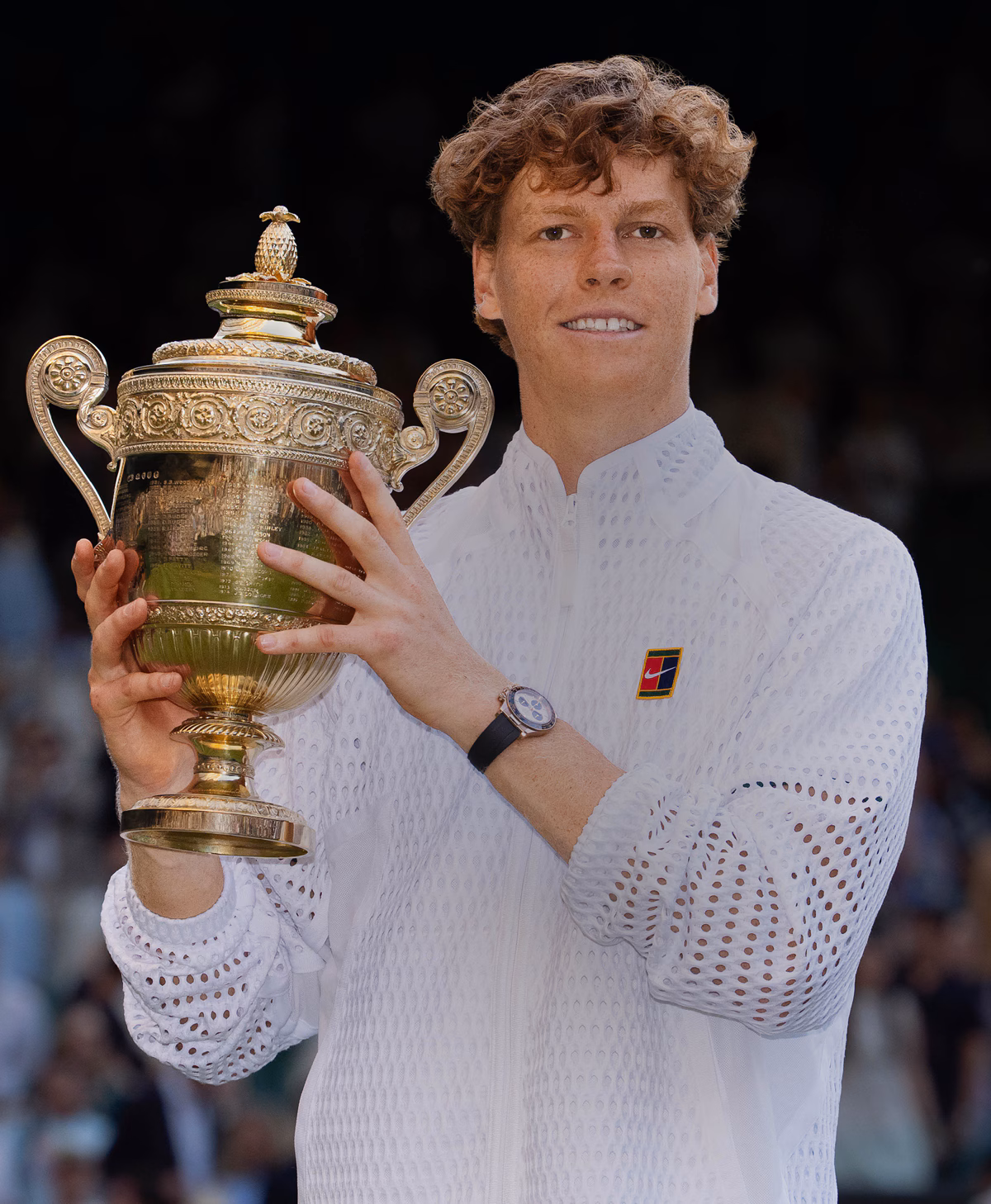 Jannik Sinner de branco segurando o troféu de Wimbledon.
