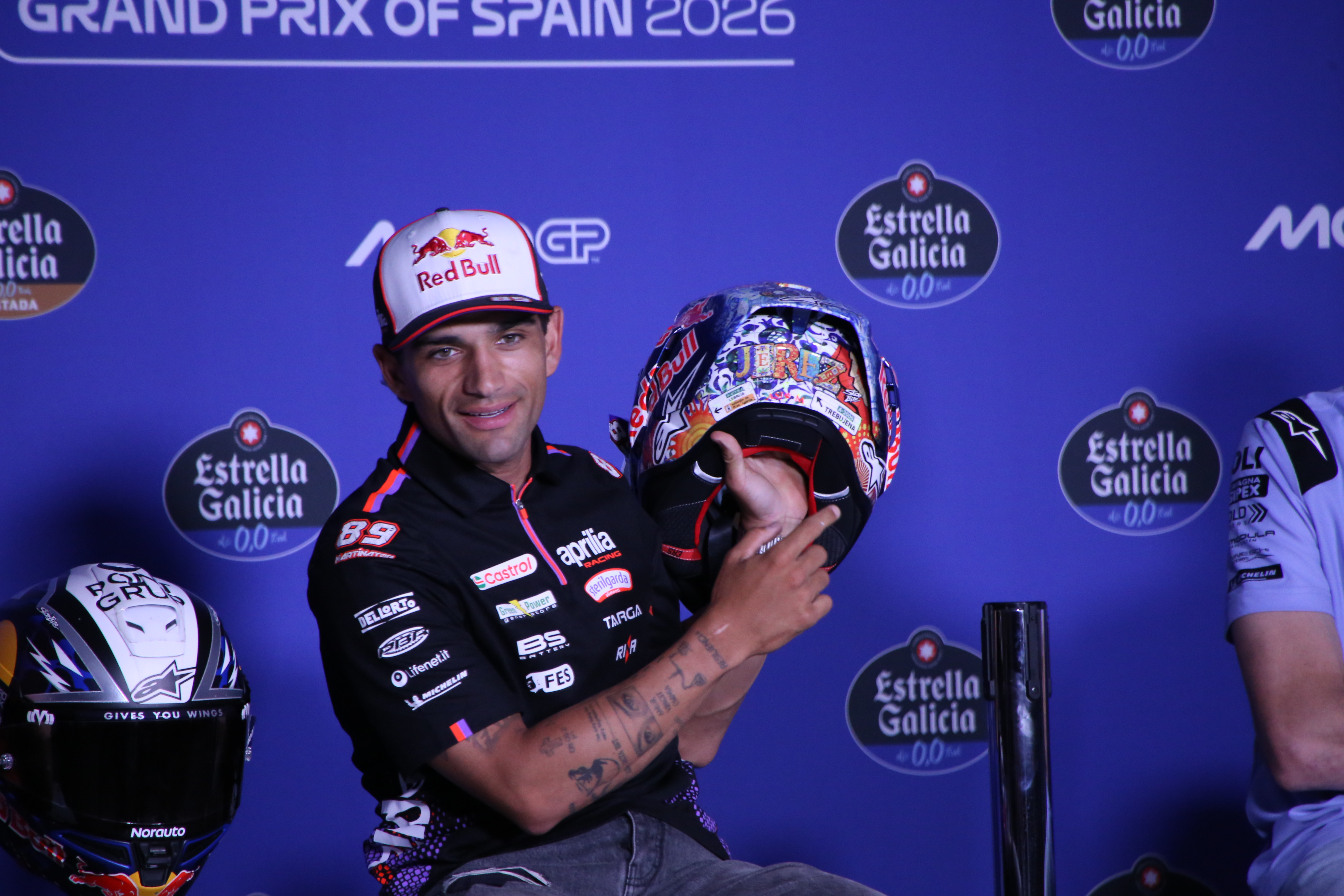 Jorge Martín com uniforme da Aprilia mostrando um capacete especial de corrida.