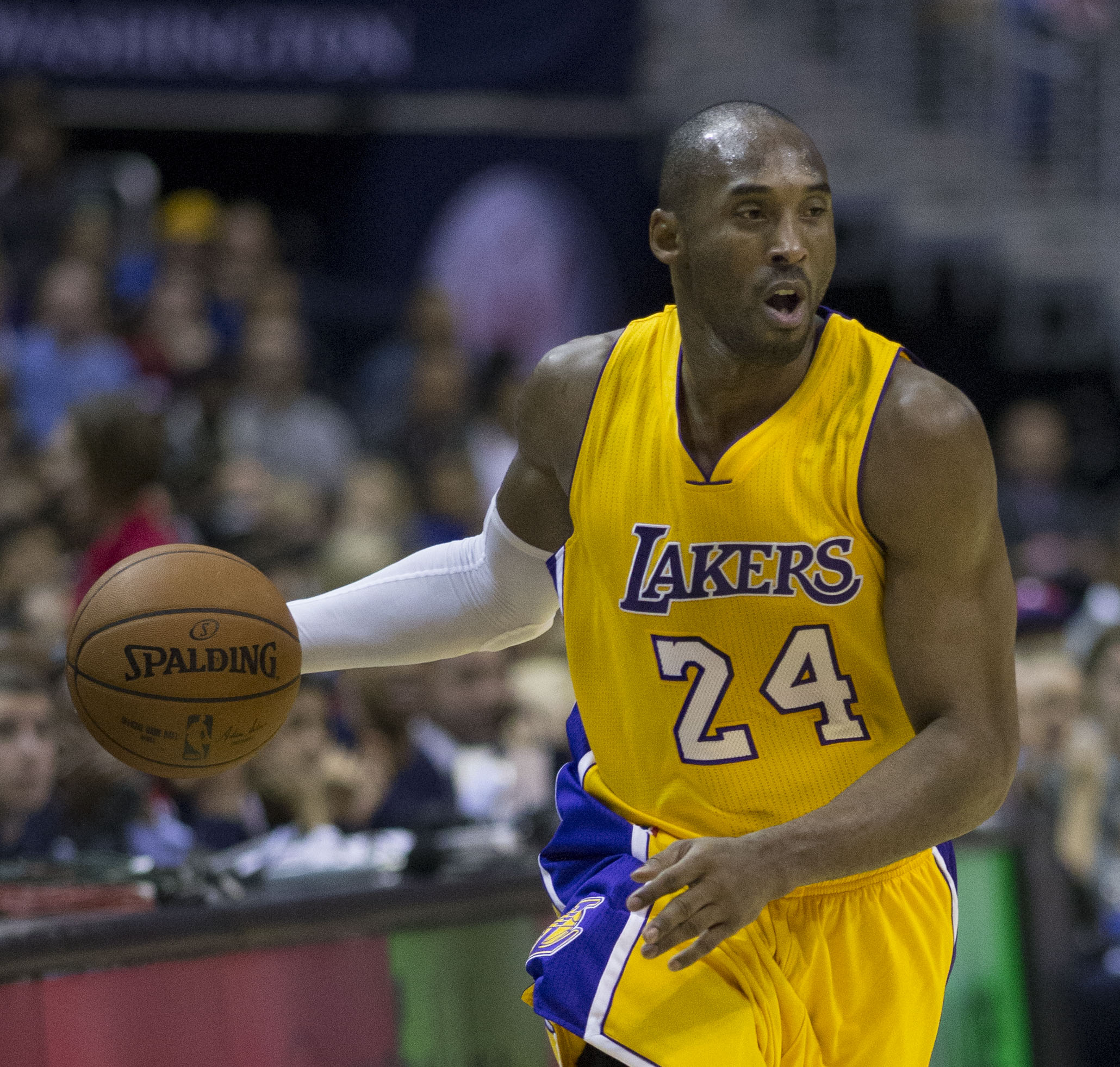 Kobe Bryant conduz a bola com o uniforme amarelo número 24 do Los Angeles Lakers.