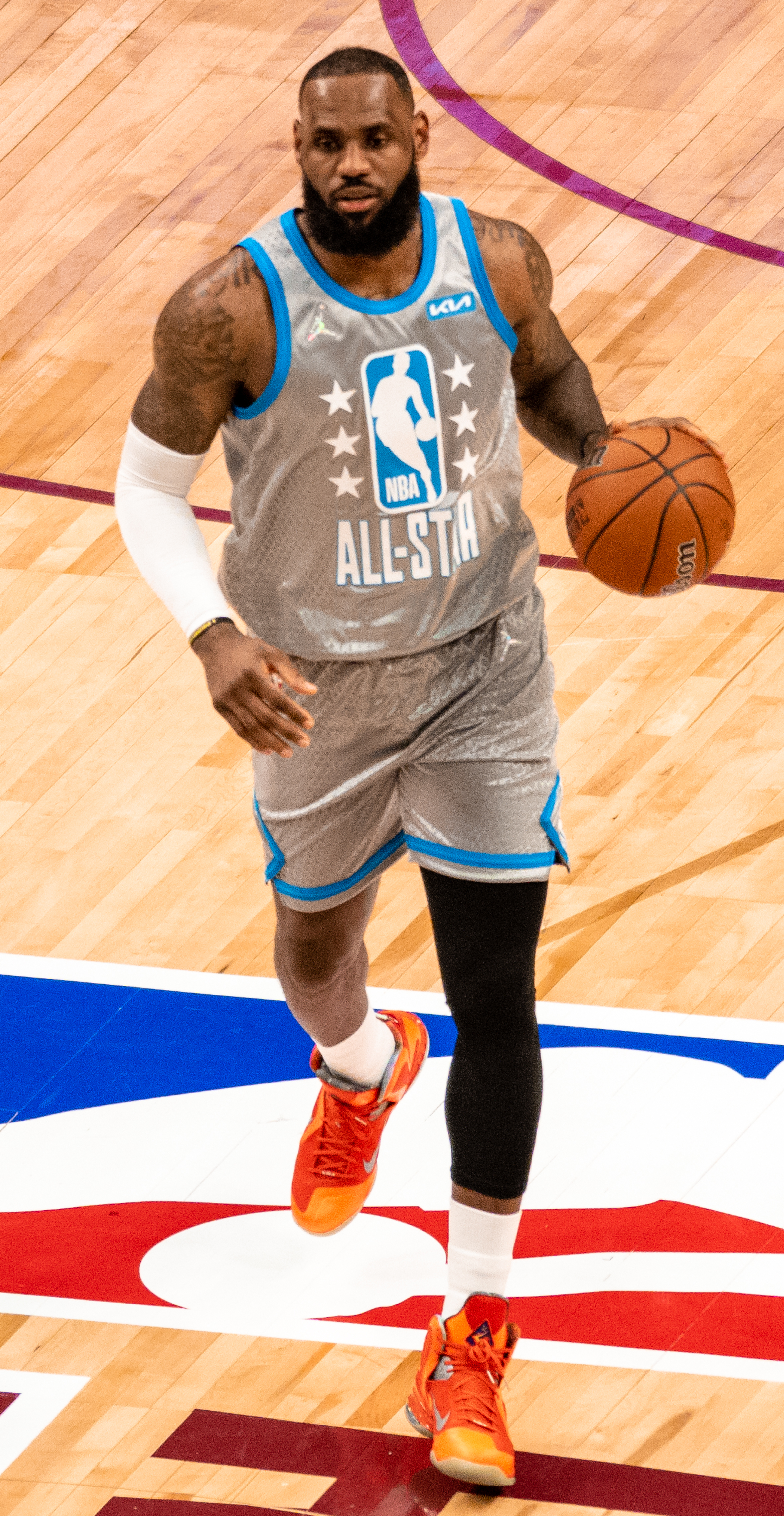 LeBron James conduzindo a bola com uniforme cinza do NBA All-Star.