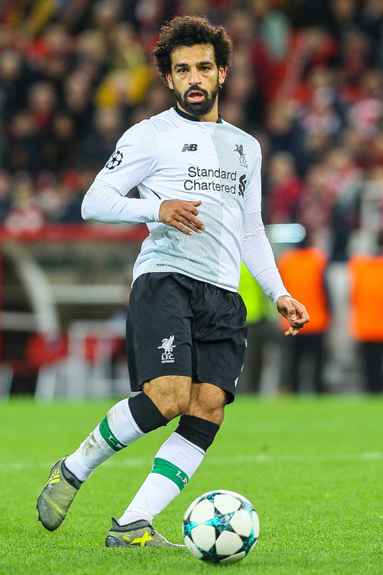 Mohamed Salah com uniforme branco do Liverpool próximo à bola durante uma partida.