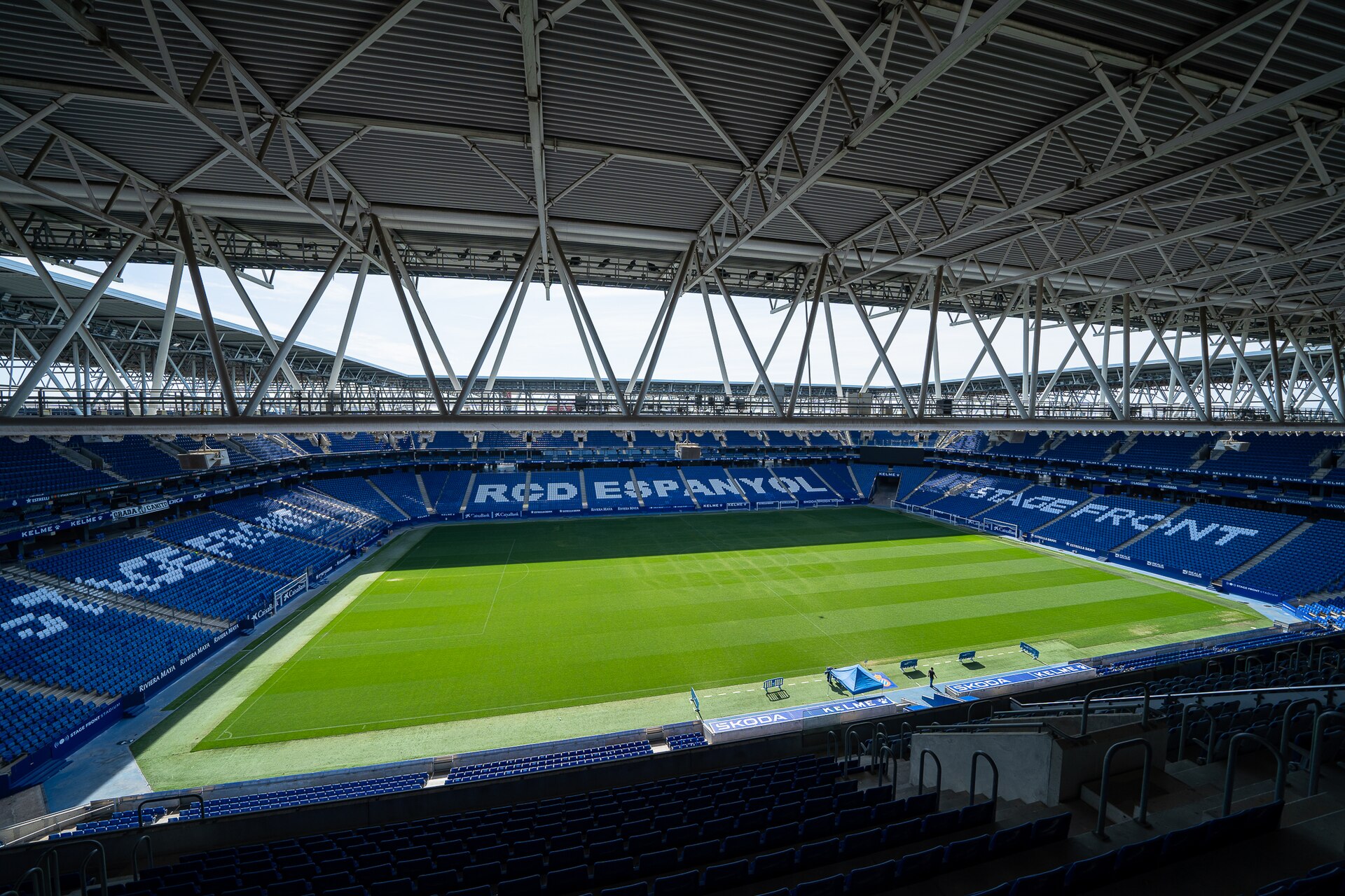 Gramado e arquibancadas azuis no interior do RCDE Stadium.