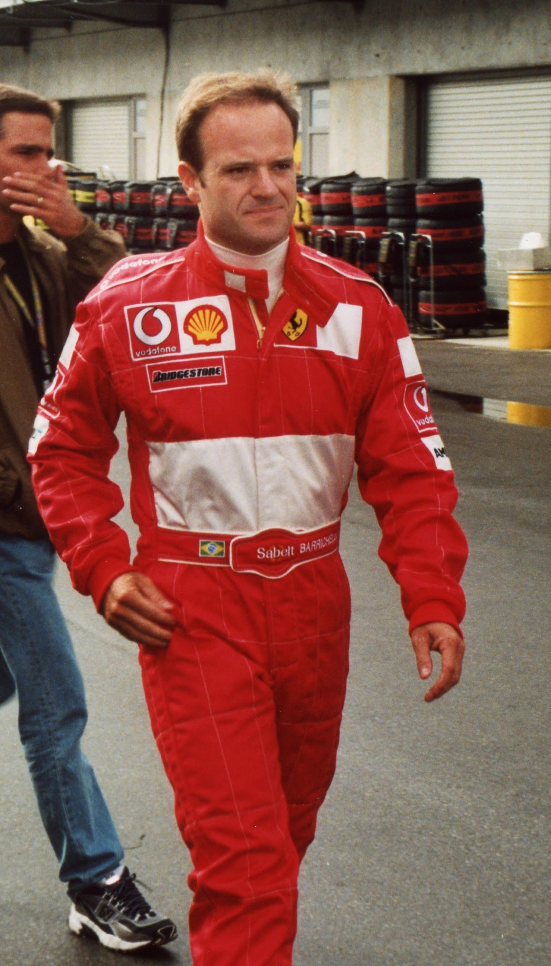 Rubens Barrichello caminhando com o macacão vermelho da Ferrari em Indianápolis.