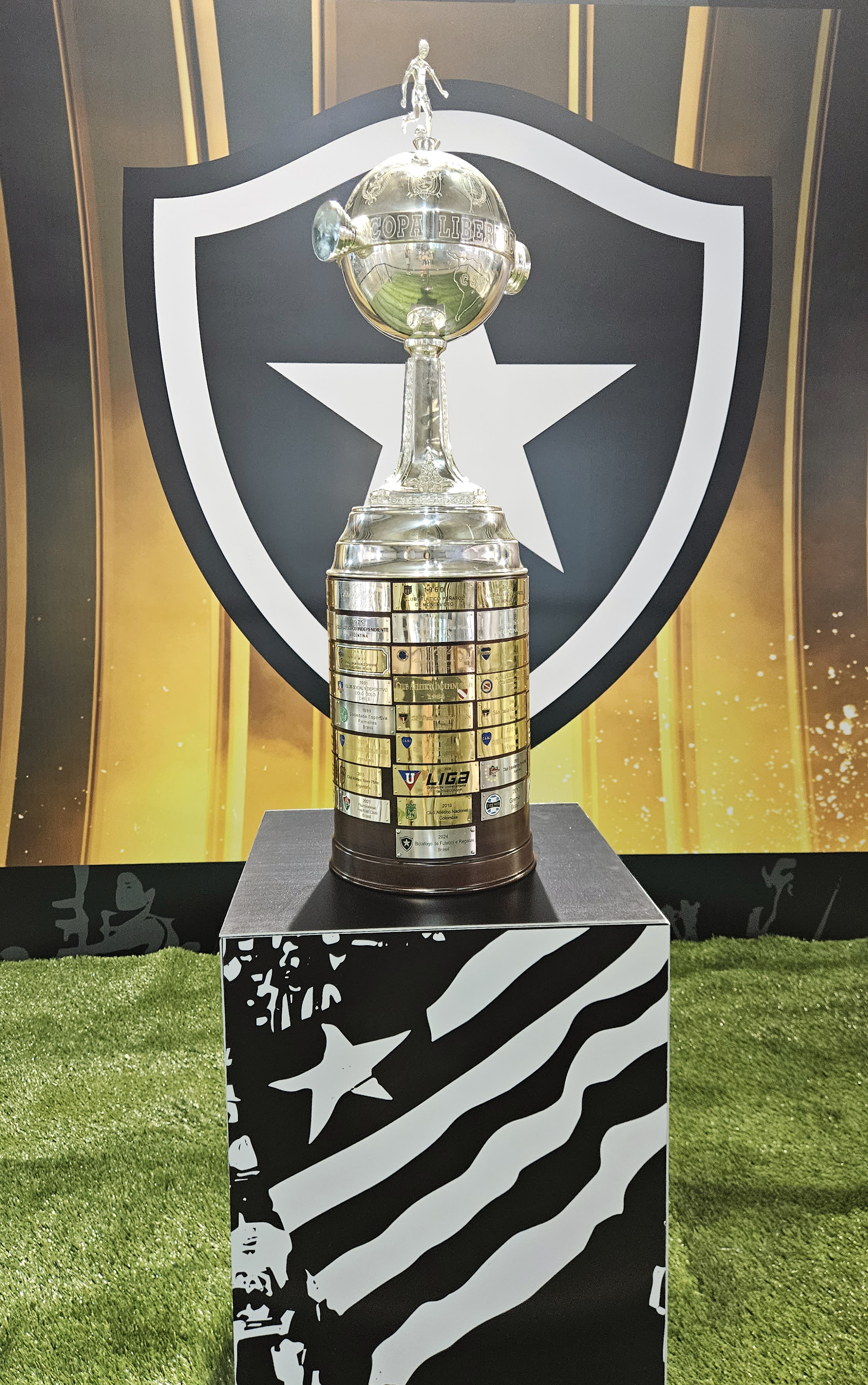 Taça da Libertadores diante do escudo do Botafogo no Estádio Nilton Santos.