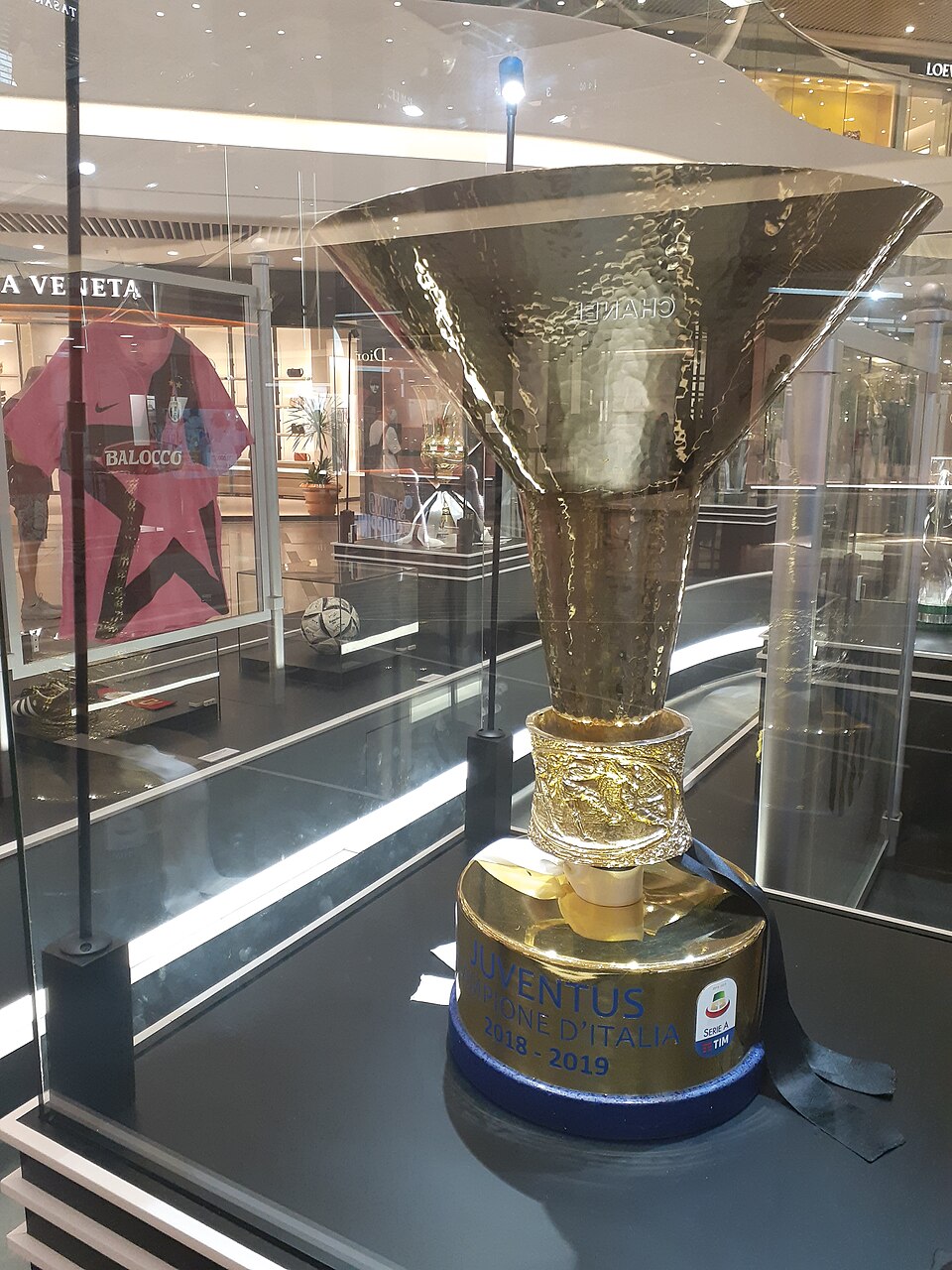 Troféu prateado da Serie A exposto sobre um pedestal branco, visto de frente.